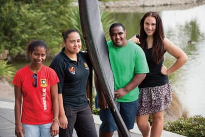 Typisch Neuseeland: Der Silberfarn zieht viele verschiedene Kulturen an Eine Gruppe Studierender steht an einem metallischen Silberfarn