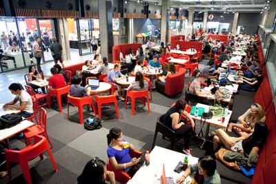 Treffpunkt für viele Studenten: die Sitzgelegenheiten in den Campusgebäuden Studenten sitzen an Tischen im Aufenthaltsbereich der Hochschule